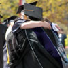 A faculty member hugs a student during the procession from the Foss Center to Si Melby Hall