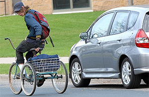 Picture of a student volunteer riding the Campus Kitchen trike.