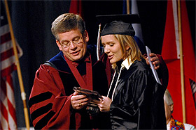 Picture of President Pribbenow presenting the award to Beth Florence at commencement.