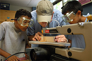 Picture of a mentor working with students in the shop.