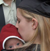 A graduate kisses her baby before Commencement.