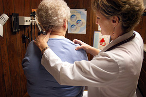 Picture of a graduate of Augsburg's PA program attending to a patient.