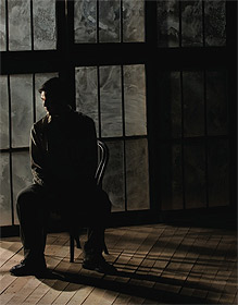 Picture of man sitting in darkened room